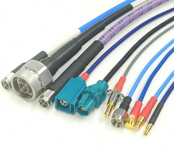 Precision RF cable assemblies including MCX, SMPM, FAKRA, and HSD series with labeled cables and connectors displayed on a test bench